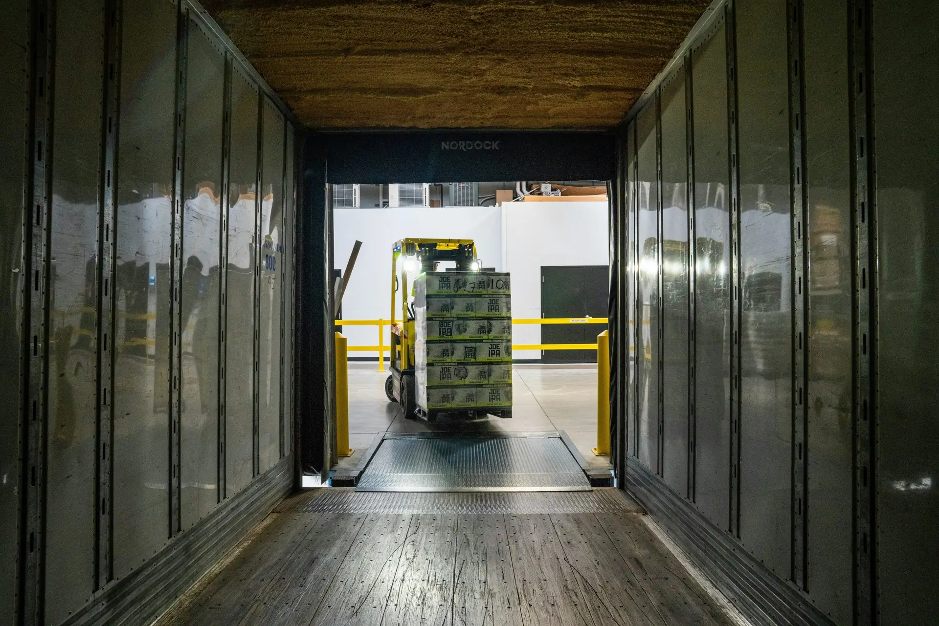 Forklift entering a trailer with a full pallet of items